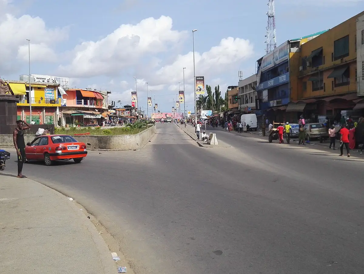 Un large boulevard bordé de commerces à Abidjan