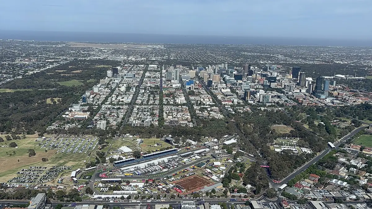 Vue aérienne du plan en damier d'Adélaïde et de ses parcs, avec les tours du centre et les banlieues jusqu'à la mer