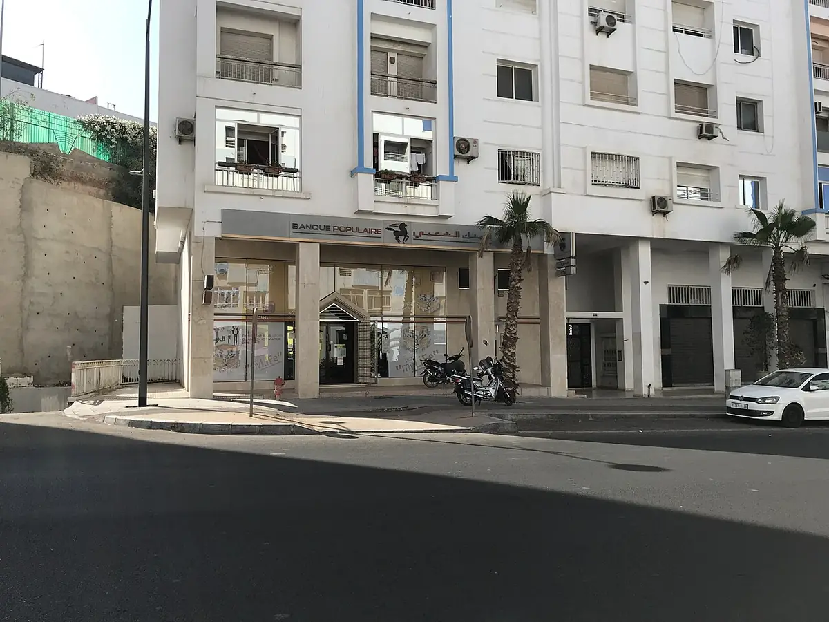 Un immeuble résidentiel blanc à l’angle d’une rue à Agadir
