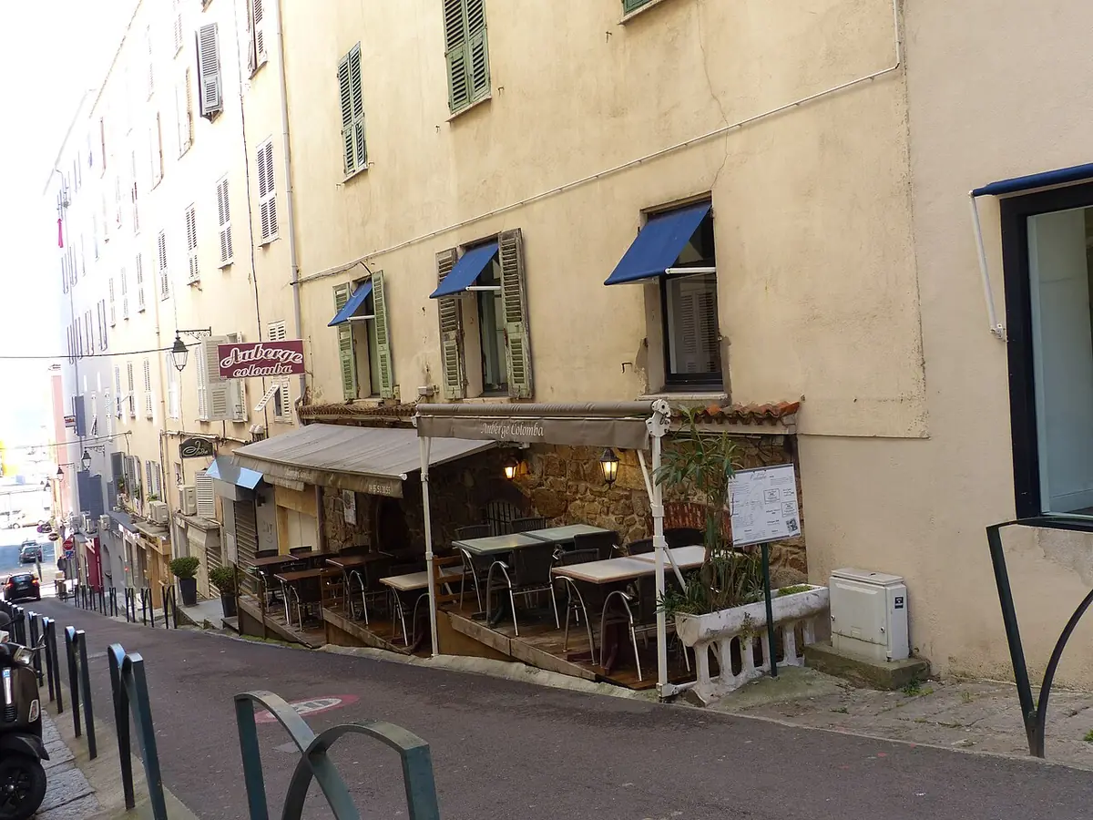 Une rue du centre d’Ajaccio avec un café en terrasse et des façades ocre