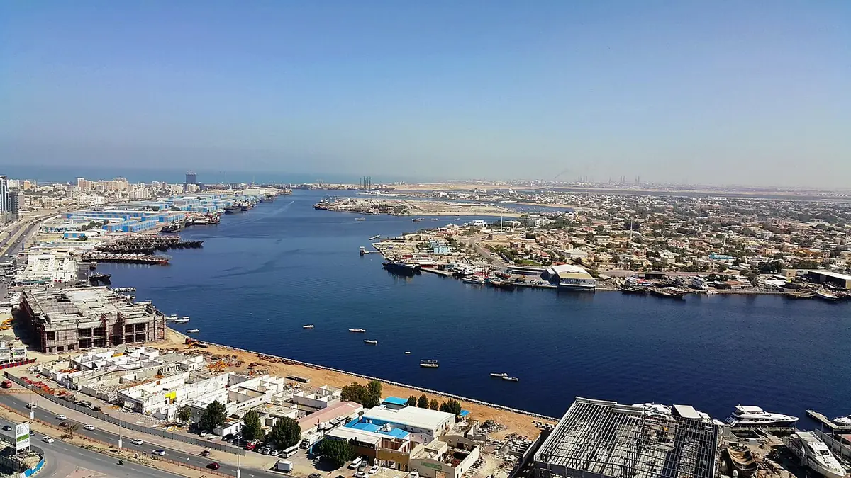 Vue aérienne du front de mer d’Al Rashidiya à Ajman, bateaux amarrés et immeubles bas