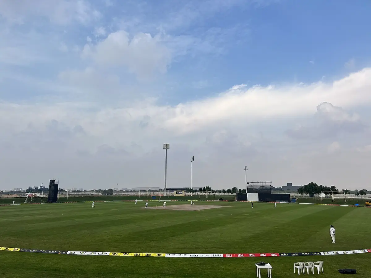 Un terrain de cricket verdoyant à Ajman, sous un ciel bleu dégagé