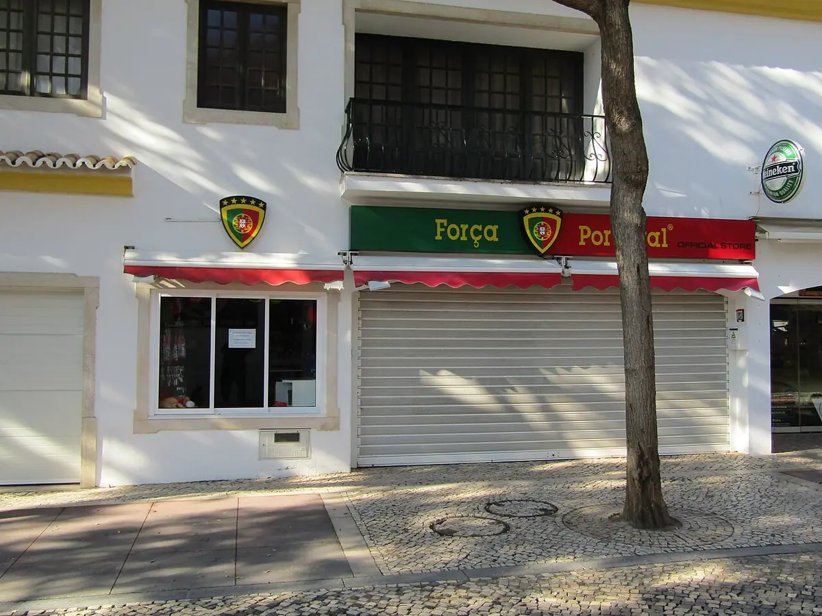 Une rue d’Albufeira bordée de commerces et de bâtiments blancs