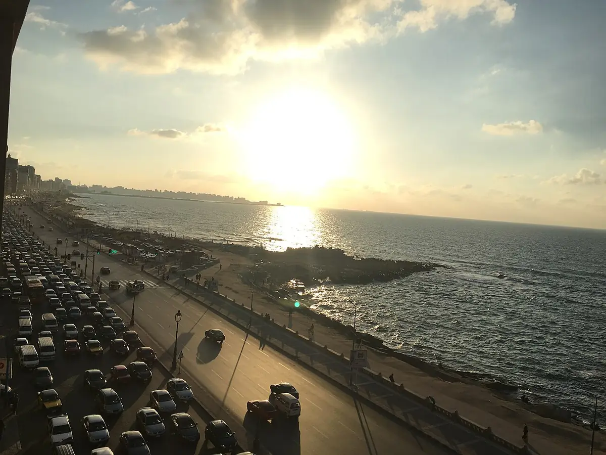 La corniche d’Alexandrie au coucher du soleil, mer calme et circulation