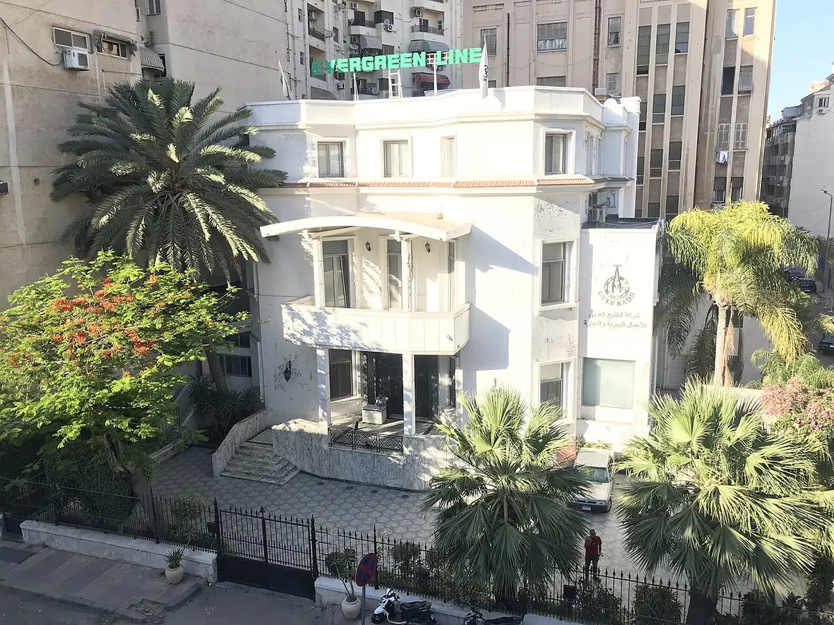 Une villa blanche à balcons entourée de palmiers, rue El Batalsa