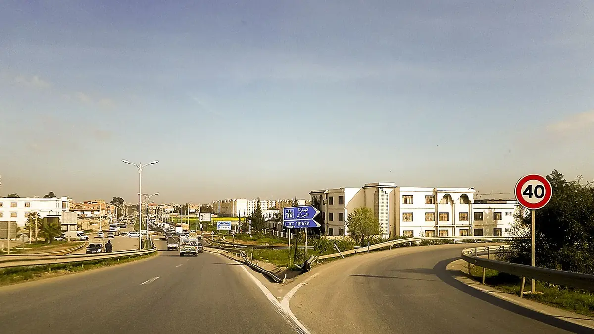 Une route bordée d’immeubles récents à la périphérie d’Alger
