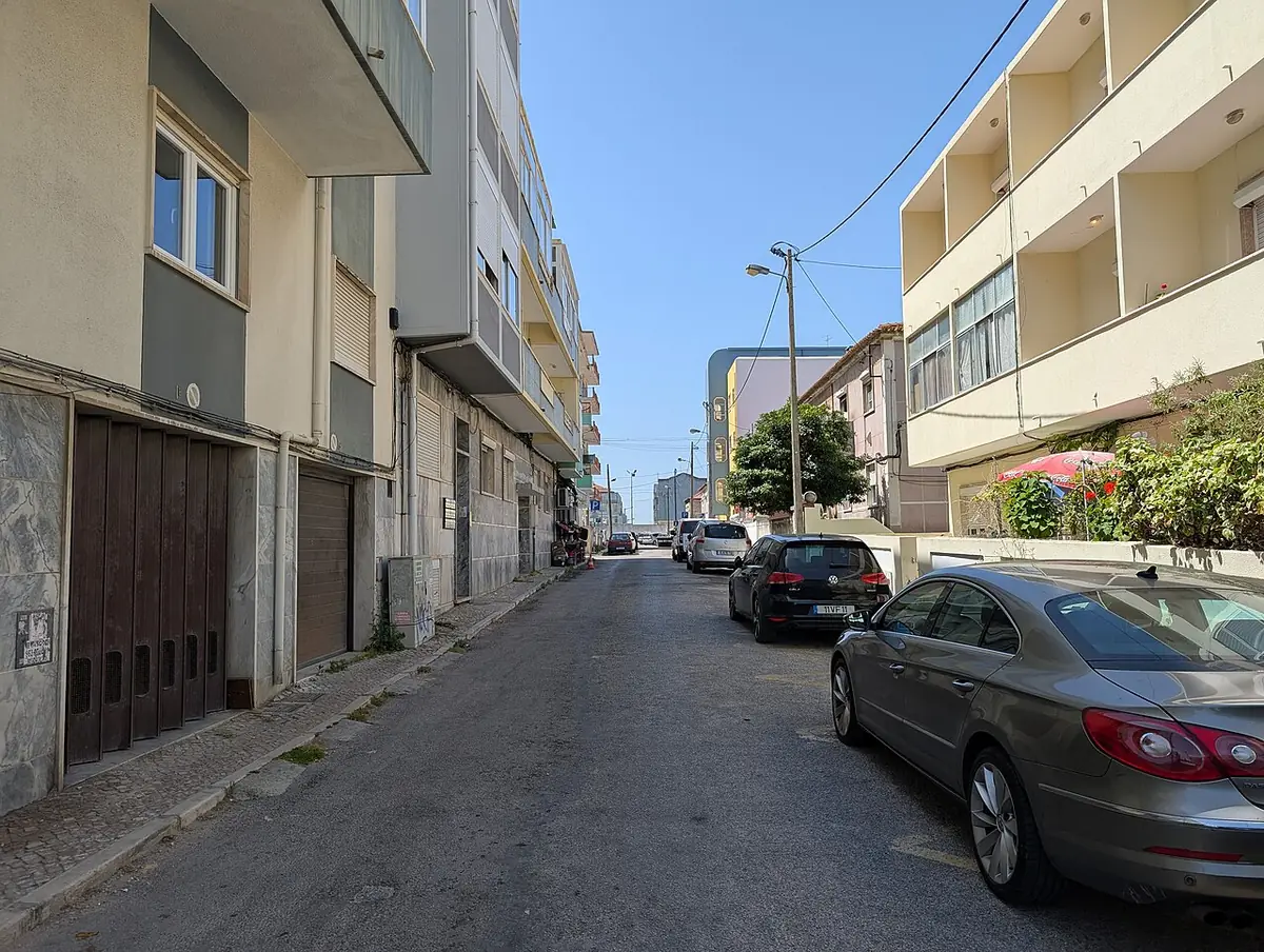 La rue Emilia Pomar à Almada, bordée d’immeubles et de voitures garées