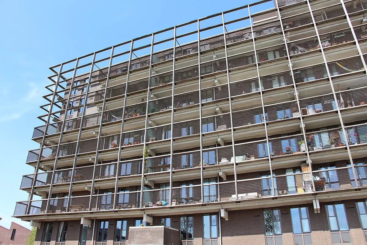 Un grand immeuble d’habitation à balcons, typique d’Amsterdam