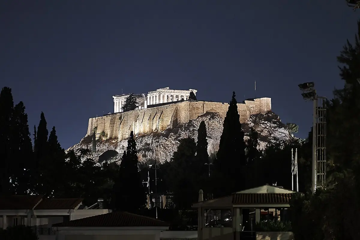 L’Acropole d’Athènes illuminée la nuit au-dessus de cyprès sombres