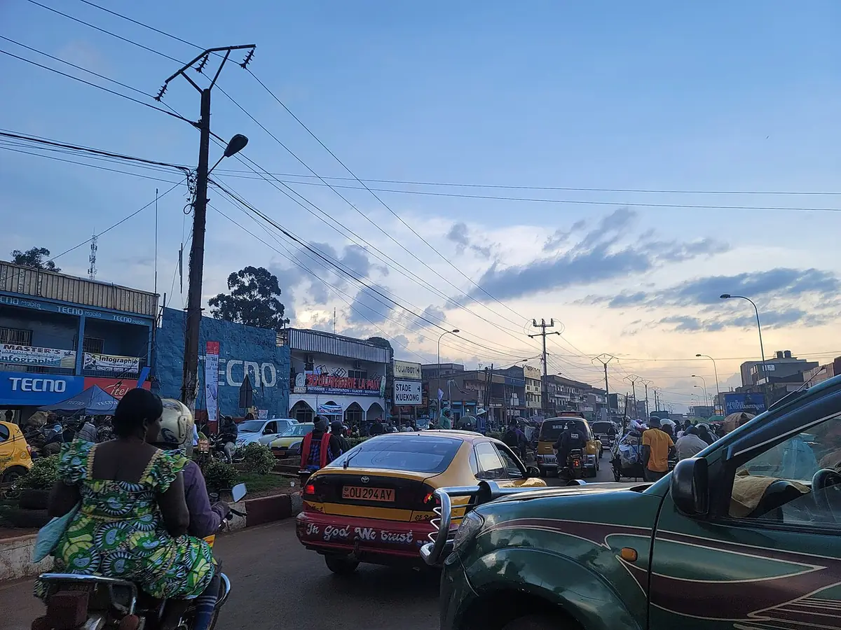 Une rue animée de Bafoussam, motos et commerces de part et d’autre