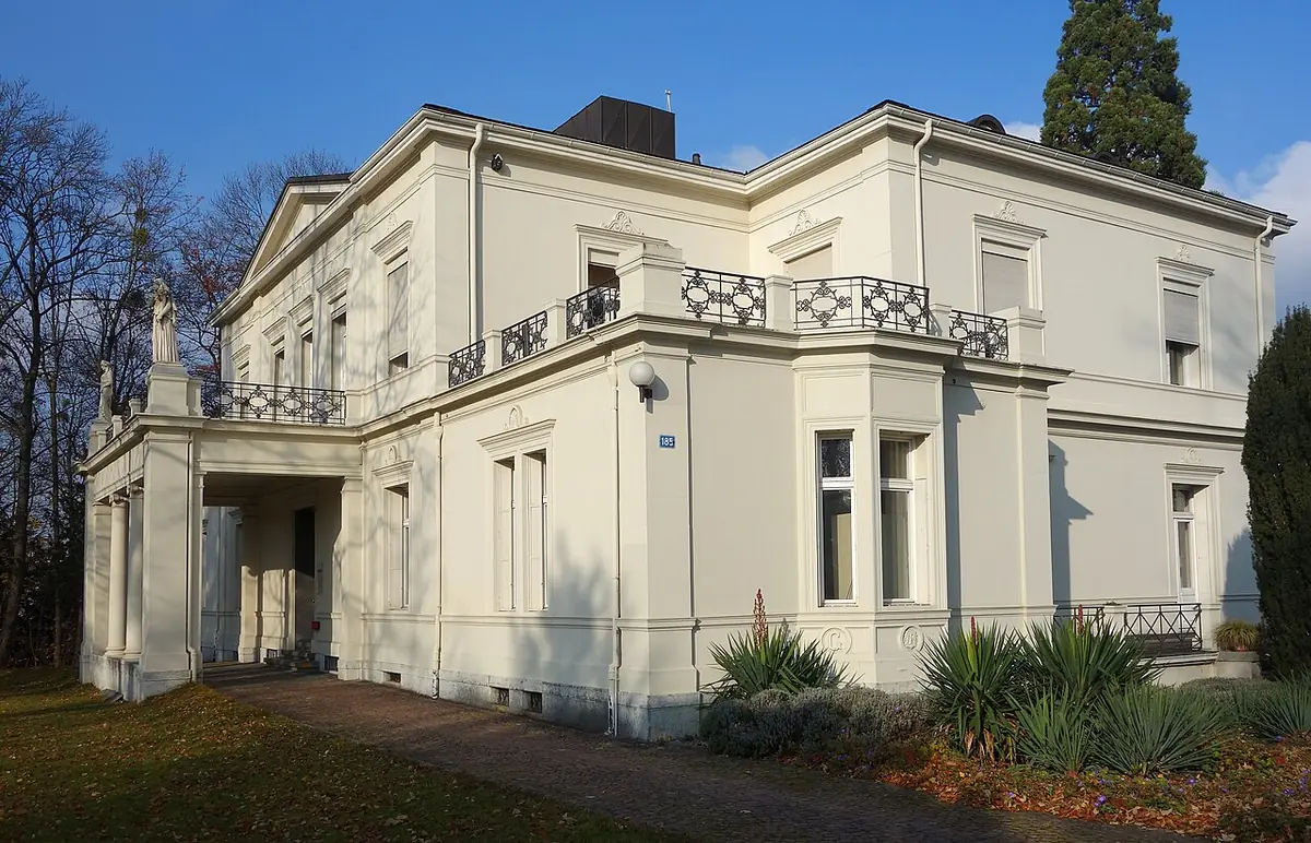 Une villa élégante à Bâle, façade blanche et jardin arboré