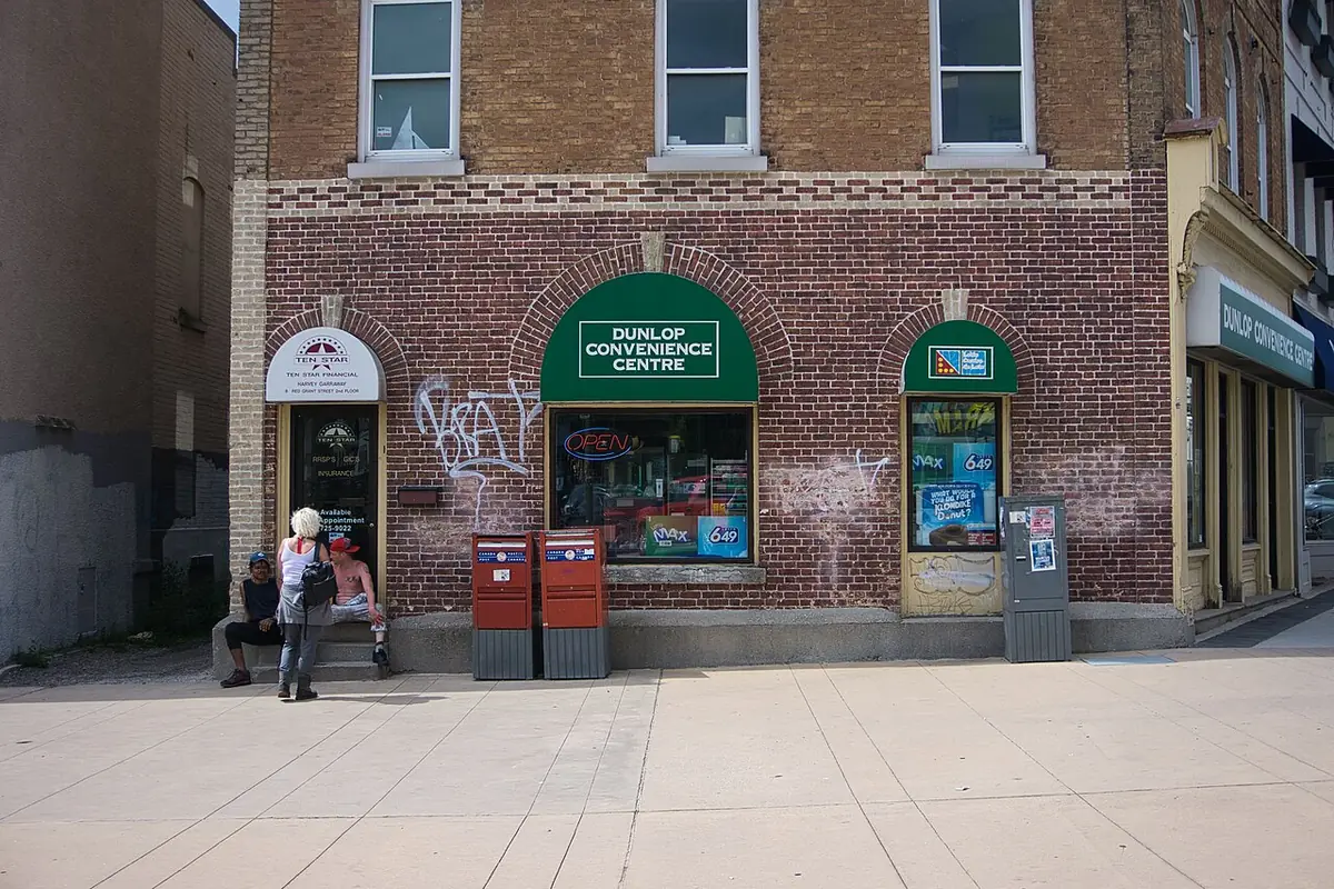 Un immeuble en brique avec commerces au coin d’une rue du centre-ville de Barrie