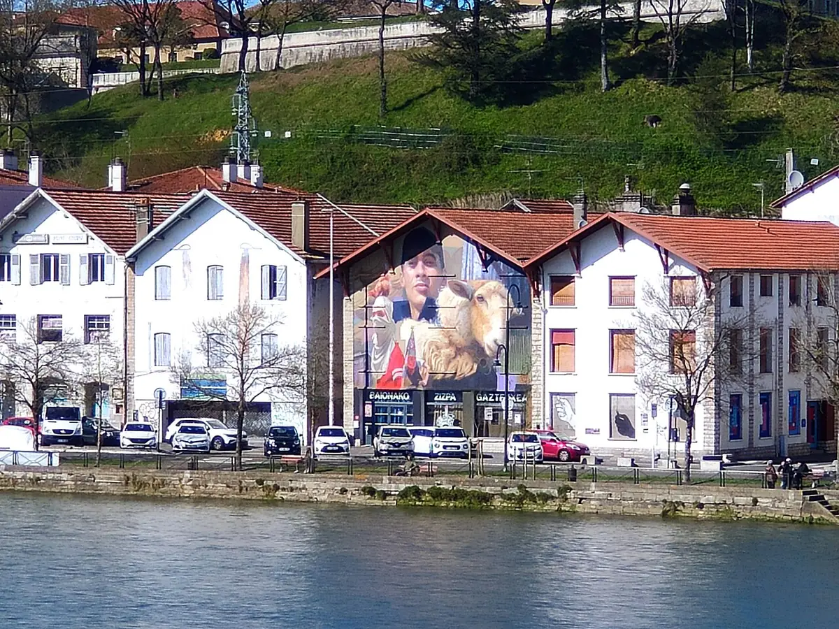 Rangée de maisons basques aux volets rouges au bord de l’eau à Bayonne