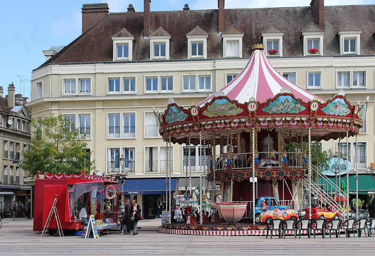 Un carrousel sur la place de Beauvais, entourée de façades élégantes