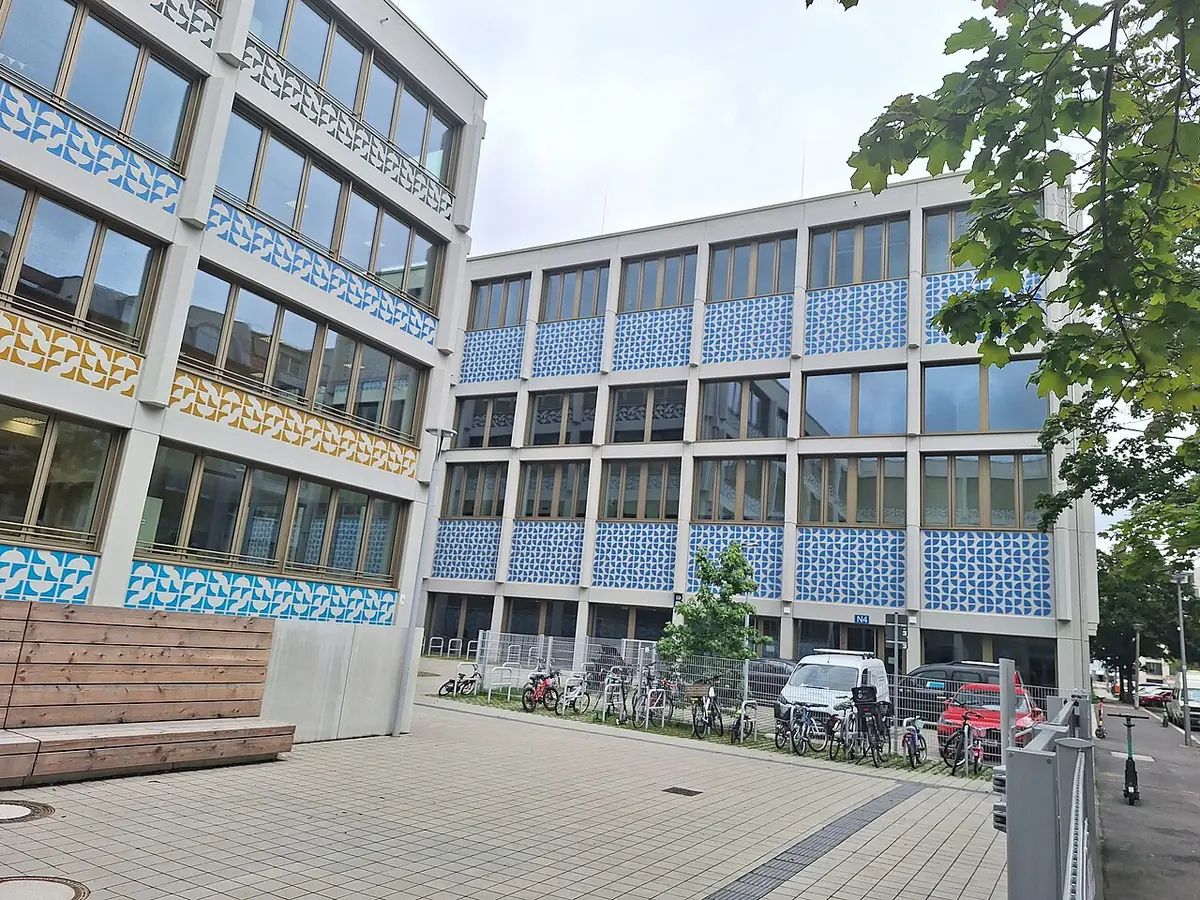 Un bâtiment moderne à façade mosaïquée autour d’une place à Berlin