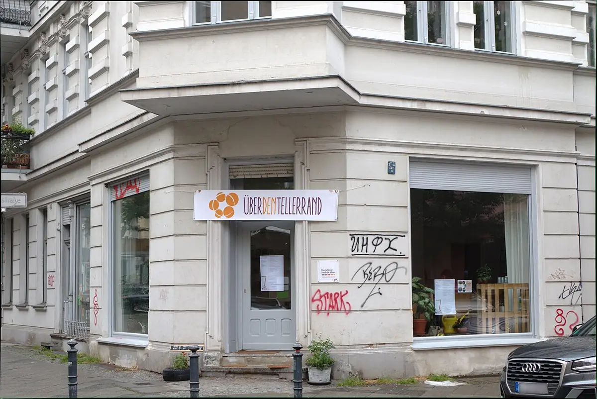 Un immeuble d’angle avec commerce au rez-de-chaussée et balcons à Berlin
