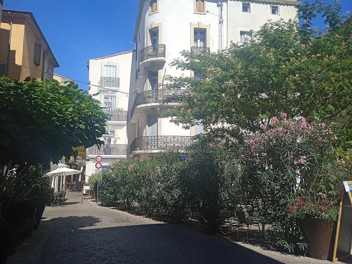 La place des Bons Amis à Béziers, ruelle ombragée aux balcons fleuris