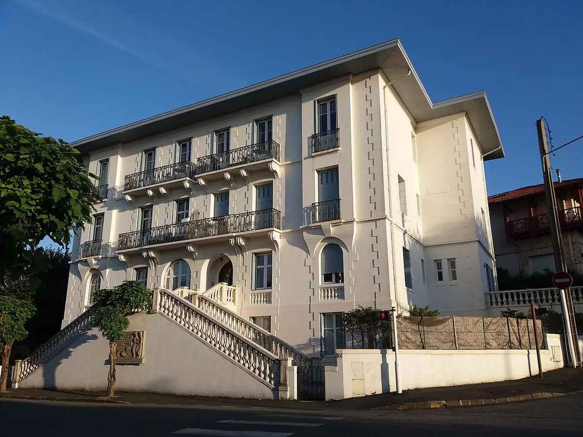 Un immeuble blanc aux balcons et arcades, rue de Verdun à Biarritz
