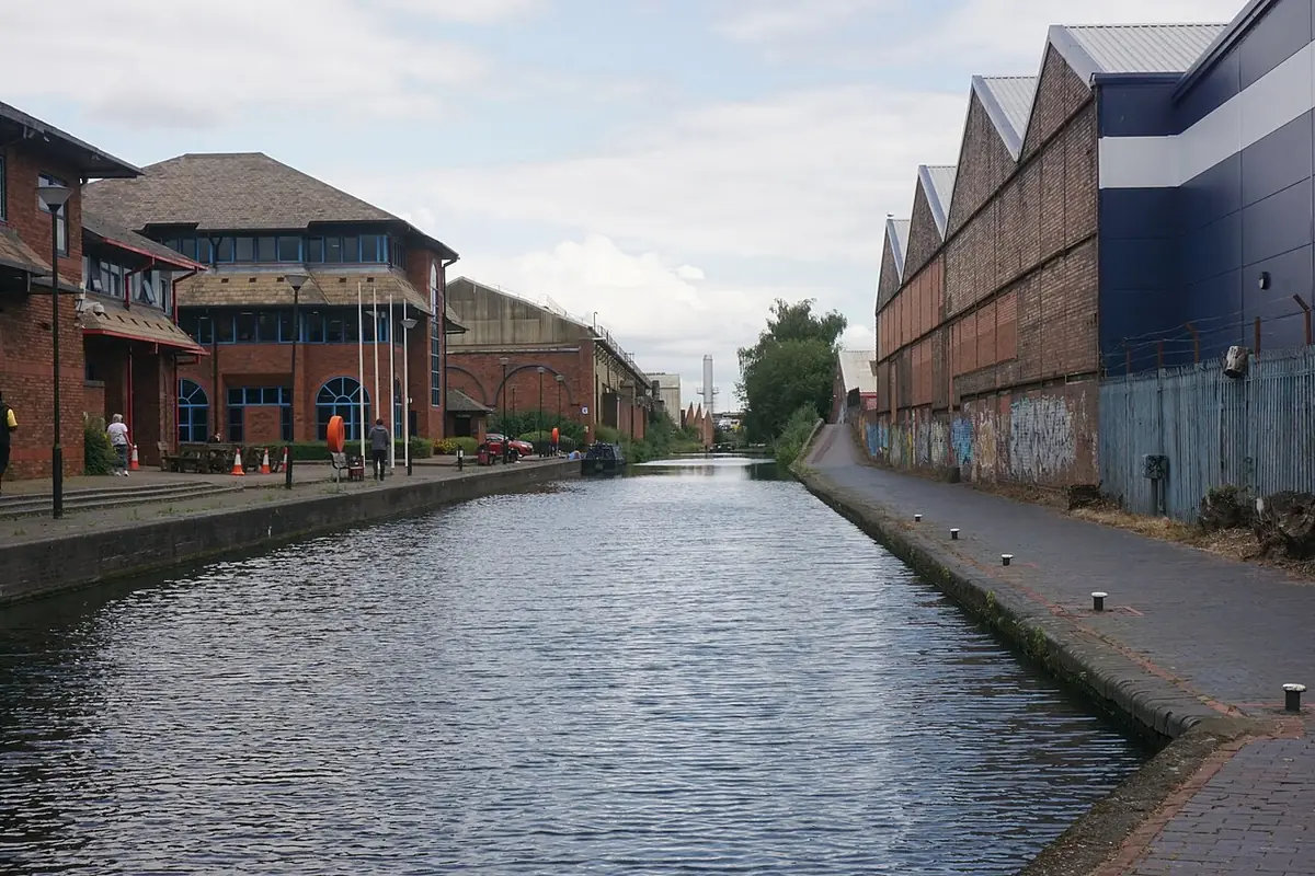 Birmingham's canal lined with brick warehouses and a glass-fronted modern building