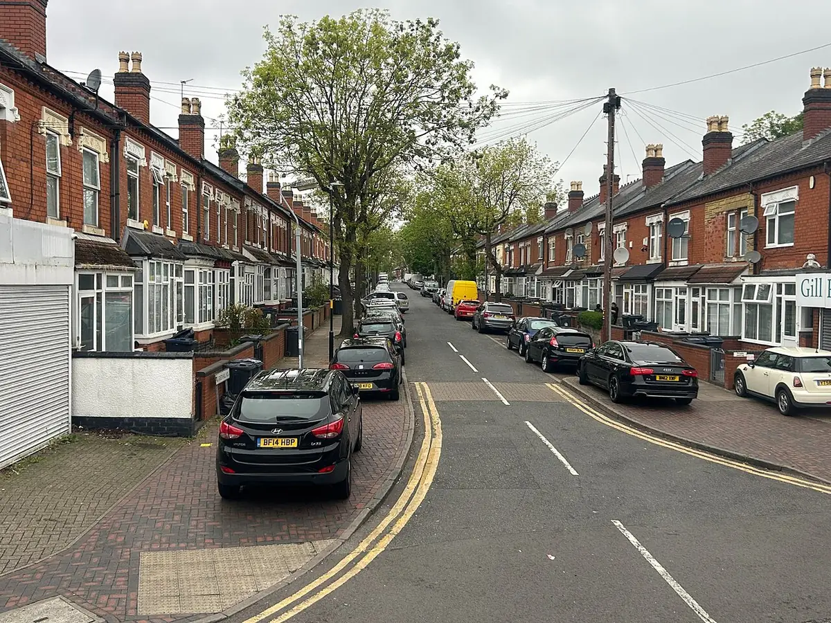 Greenhill Road in Handsworth lined with red-brick terraced houses and parked cars