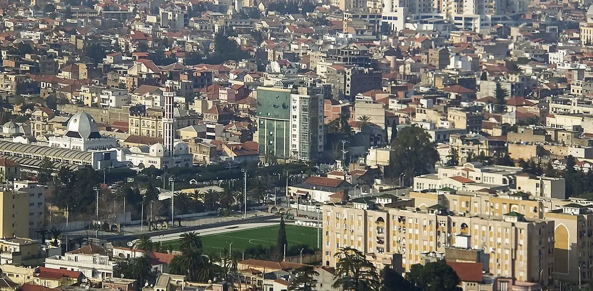 Vue aérienne de Blida et de ses toits denses, avec un stade visible