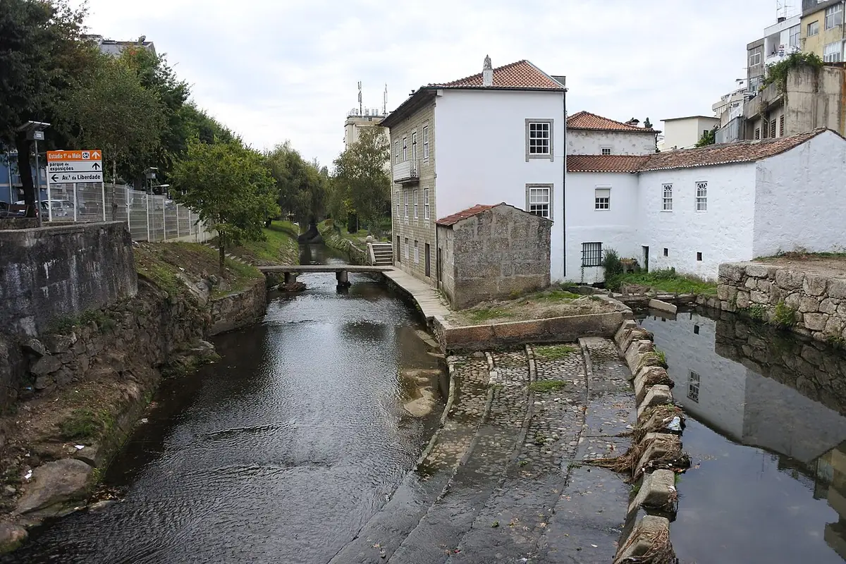 Le chemin le long de la rivière à Braga, bordé de maisons blanches