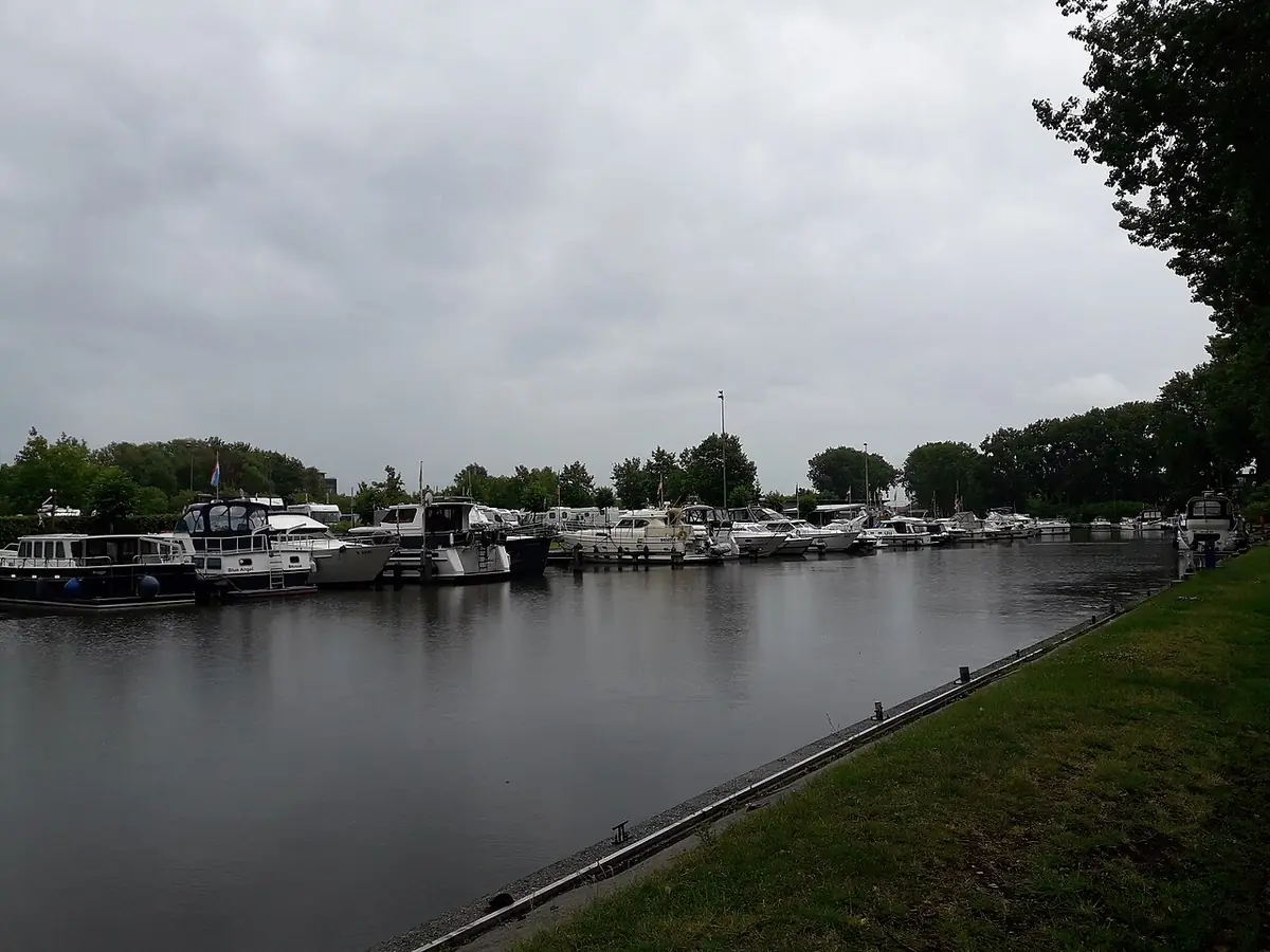 Des bateaux amarrés le long d’un canal bordé de verdure à Bruges