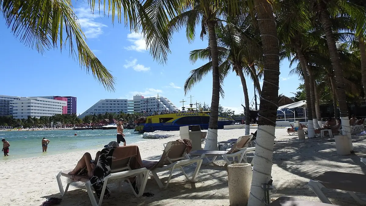 La plage de la zone hôtelière de Cancún, bordée de palmiers et de transats