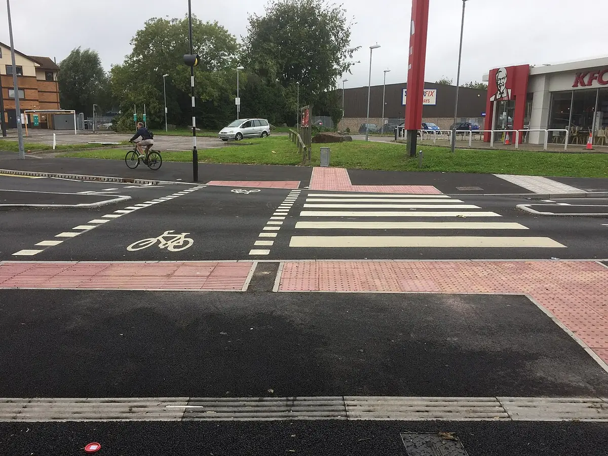 Un cycliste traverse un carrefour dans une rue de Cardiff