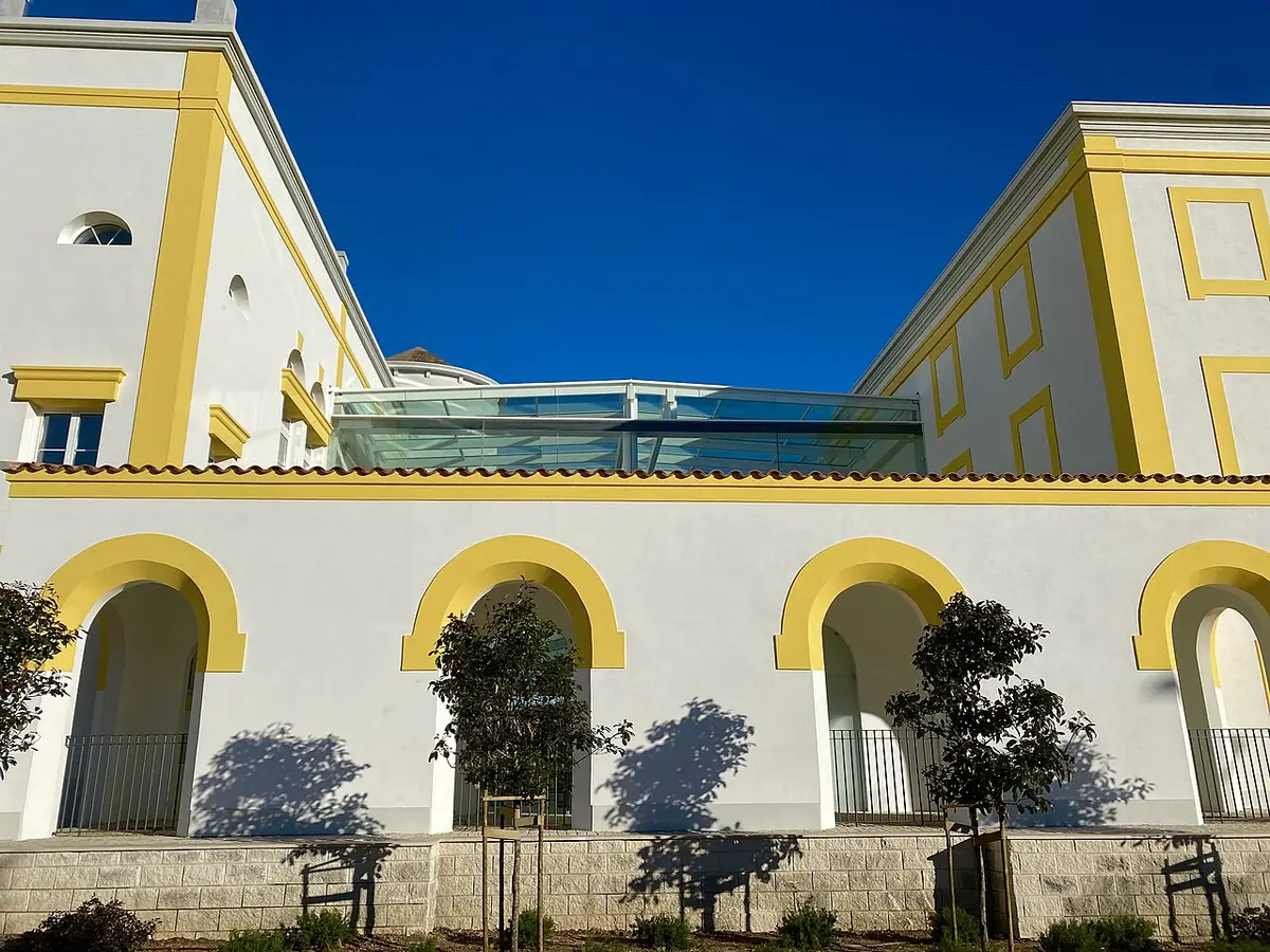 Un bâtiment aux arcades jaunes et blanches, architecture typique de la région