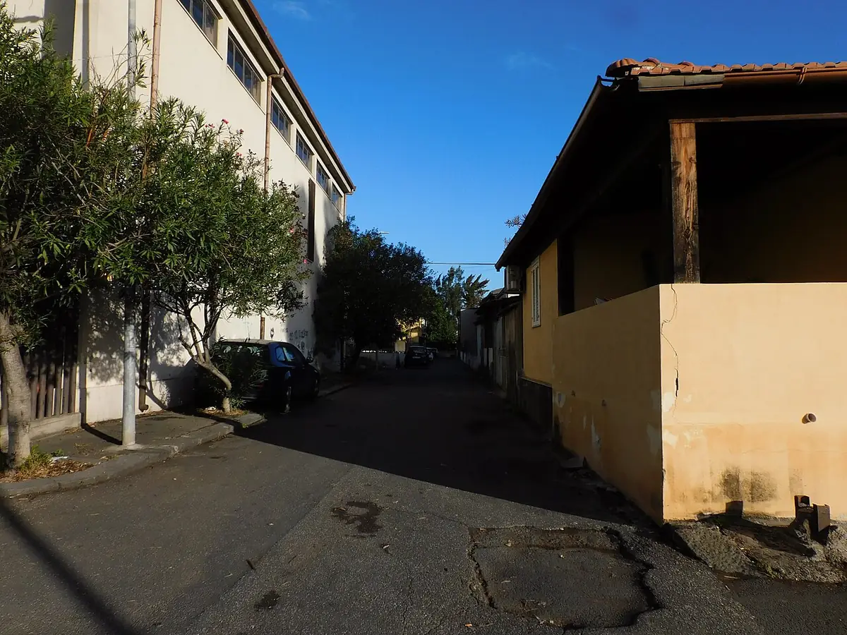 Une ruelle calme bordée de façades ocres, à Catane