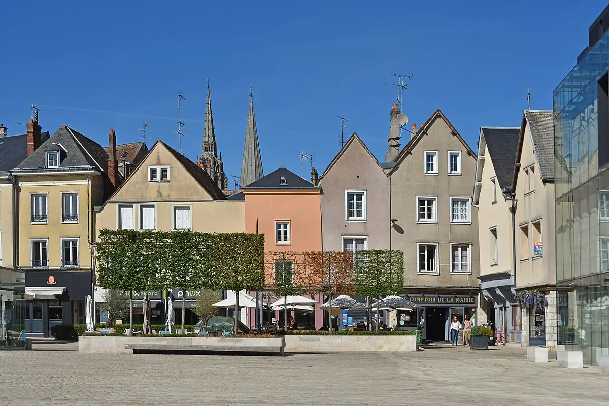 Maisons colorées et terrasses de café sur une place de Chartres
