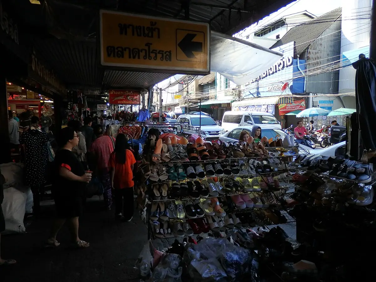 A lively market street in Chiang Mai lined with stalls and shoes for sale