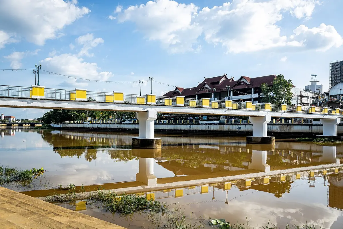 Un pont traversant la rivière Ping bordé de bâtiments à Chiang Mai