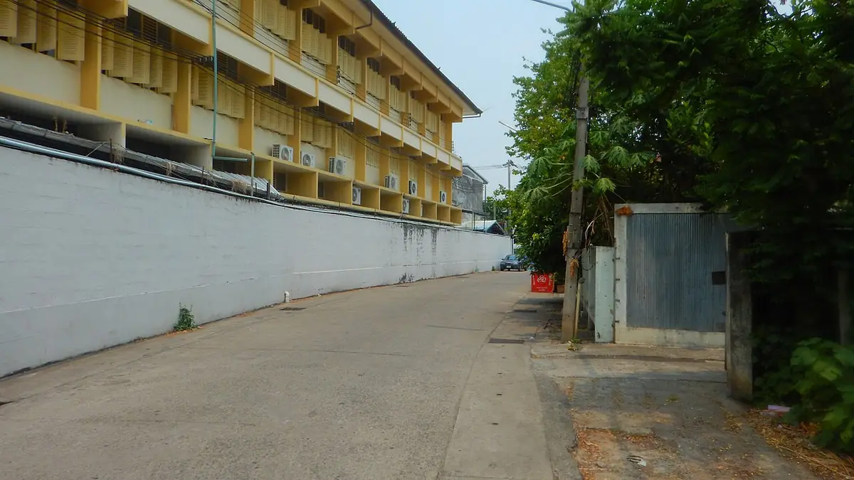 Une rue résidentielle calme à Chiang Mai bordée de bâtiments bas