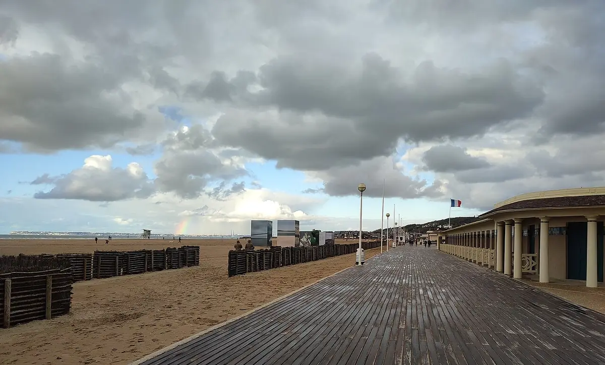 Les planches de Deauville longeant la plage sous un ciel nuageux