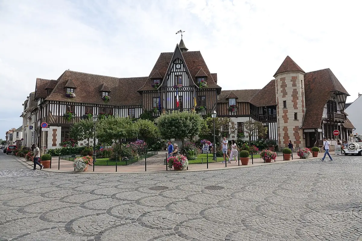 L’hôtel de ville de Deauville, bâtiment à colombages derrière une place pavée fleurie