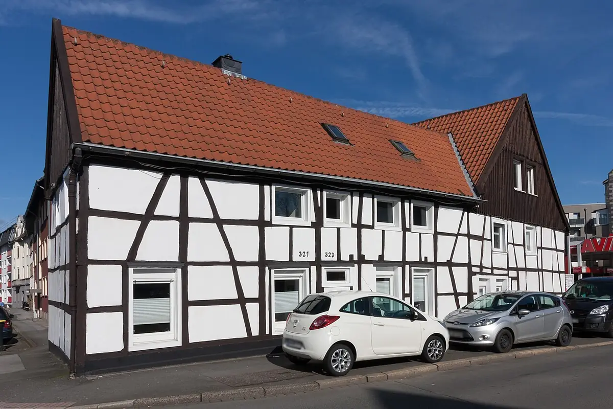 Une maison à colombages typique de Dortmund, entourée de voitures garées