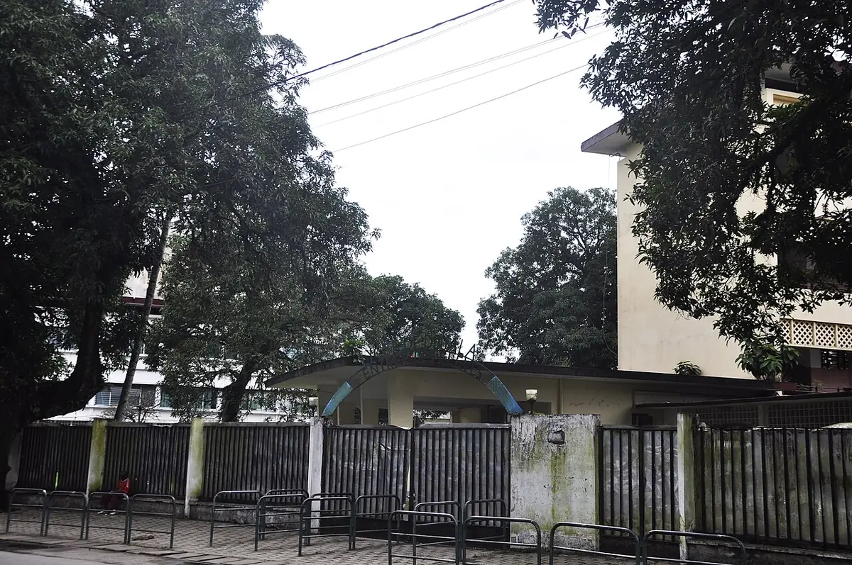 Le lycée Joss de Douala, bâtiment classé, derrière sa clôture sur une rue arborée