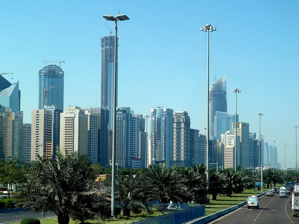 Palm-lined avenue with Abu Dhabi's skyscrapers rising behind