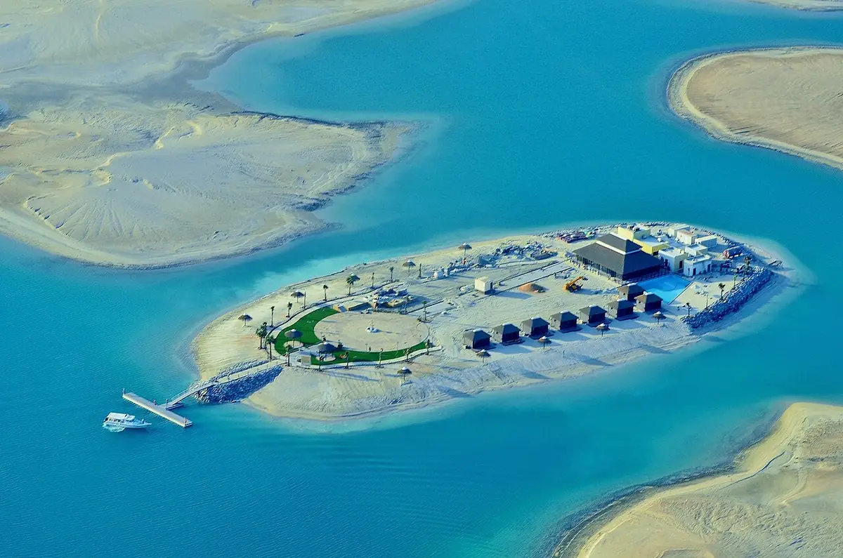 An aerial view of a palm-fringed island resort in the turquoise waters of the World Islands