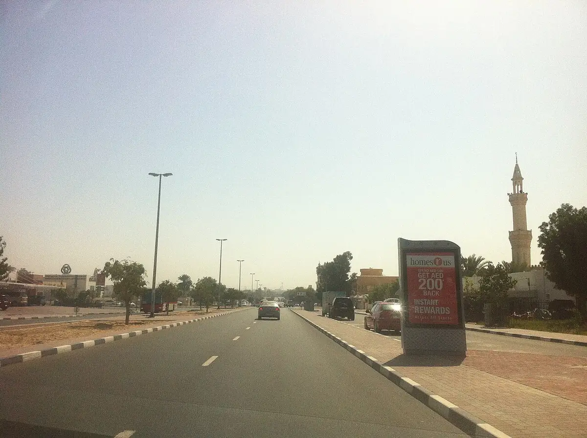 A quiet residential street in Al Rashidiya with a mosque minaret in view