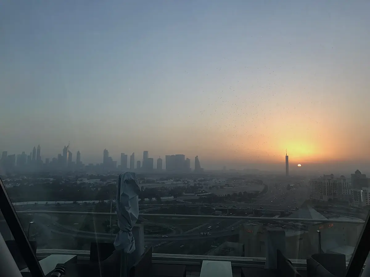 La skyline de Dubaï s’illuminant au coucher du soleil, vue depuis Wafi Mall à travers un ciel voilé