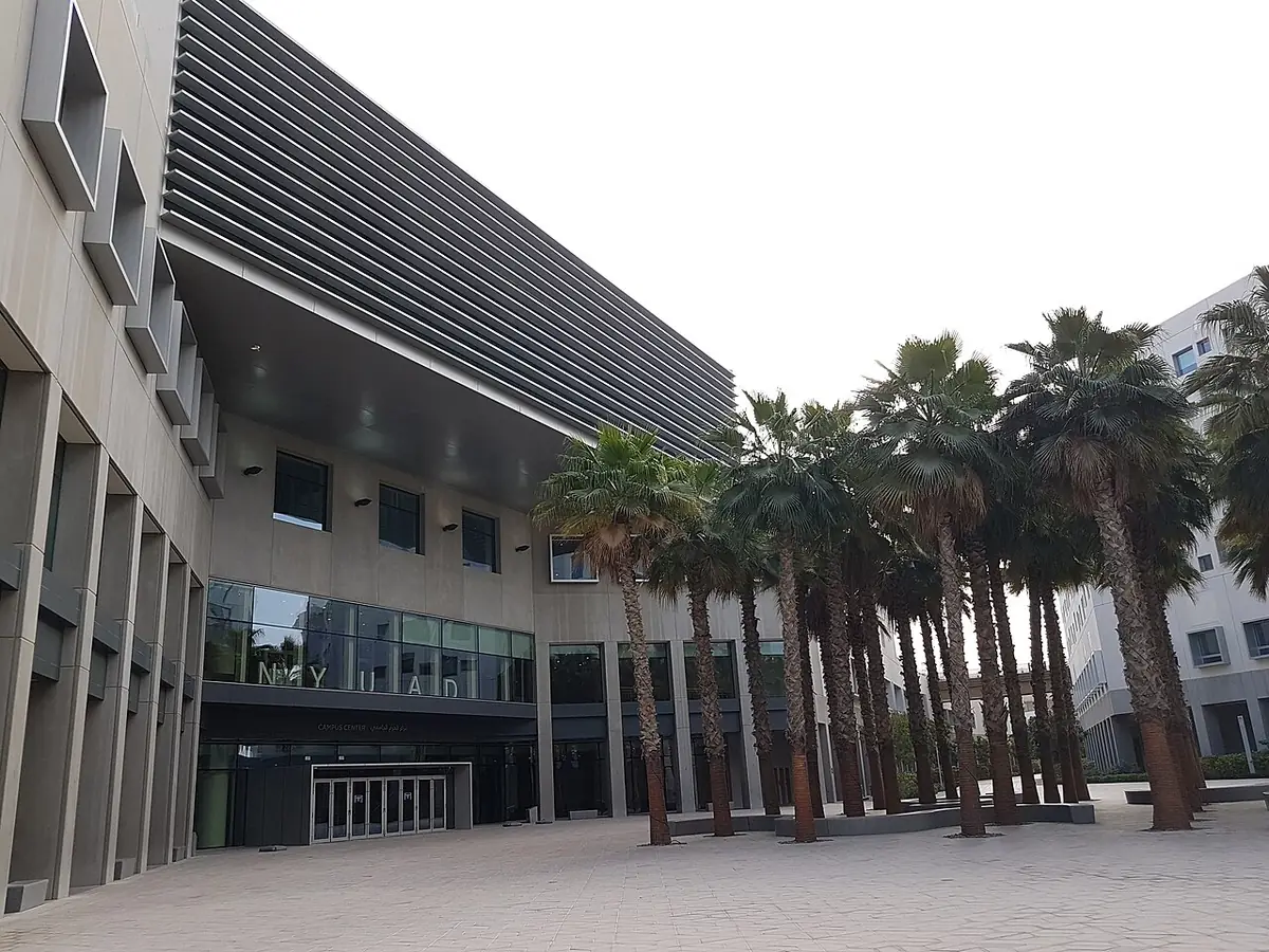 The NYU Abu Dhabi campus building lined with palm trees on Saadiyat Island
