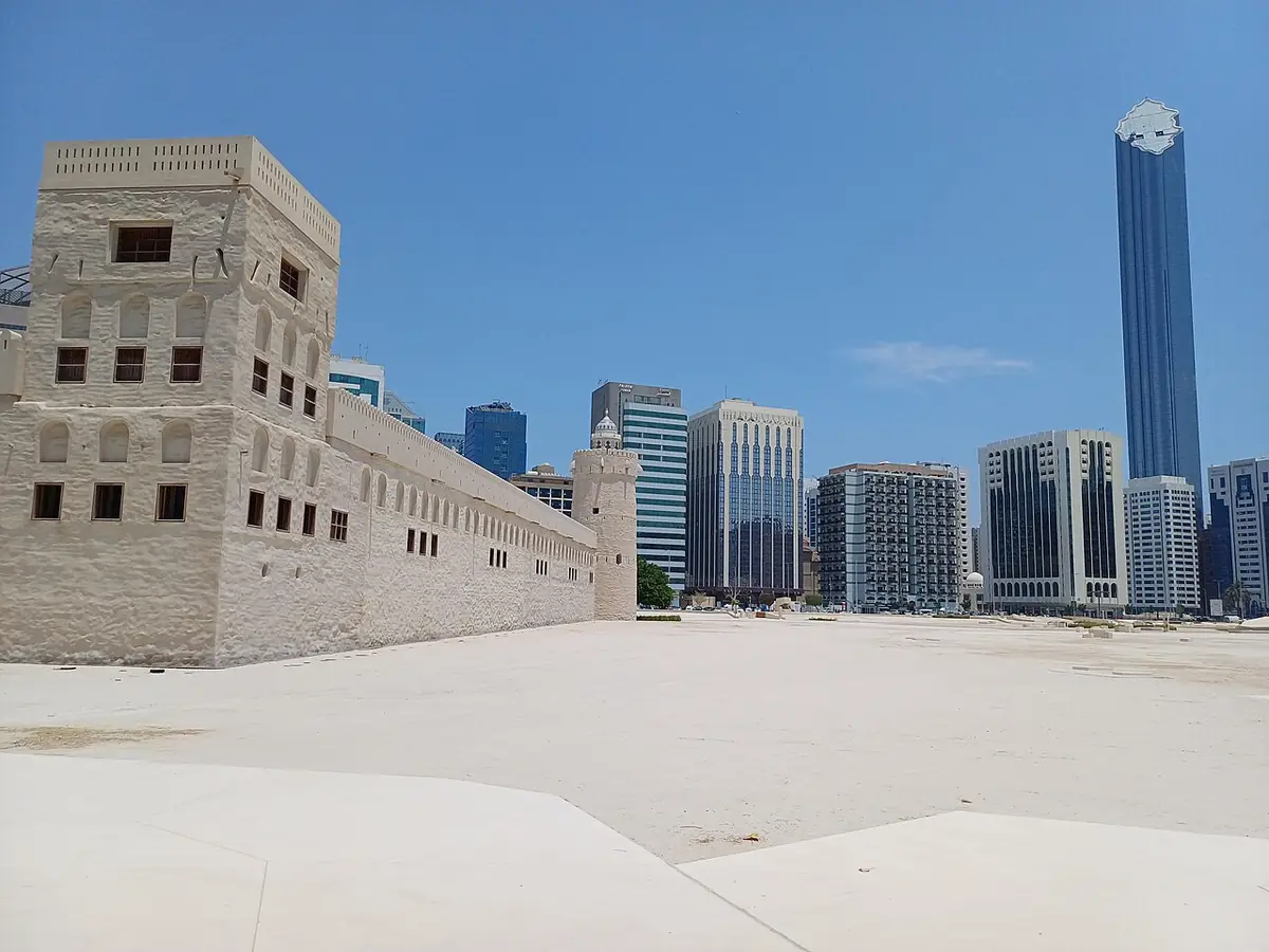 Qasr al-Hosn's white fort walls with the Abu Dhabi skyline behind