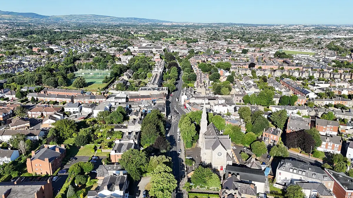 Aerial view of Rathgar, Dublin, with rows of houses, gardens, church spires and hills on the horizon