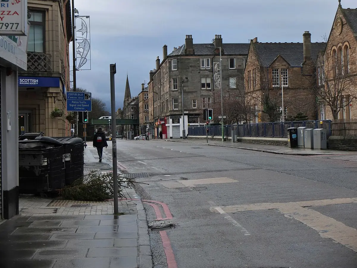 Dalry Road à Édimbourg, trottoirs et immeubles de pierre au loin sous un ciel gris