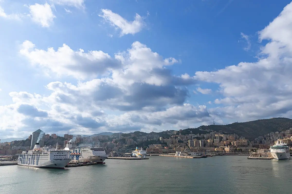 Le port de Gênes avec des ferries à quai, la ville étagée sur les collines au fond
