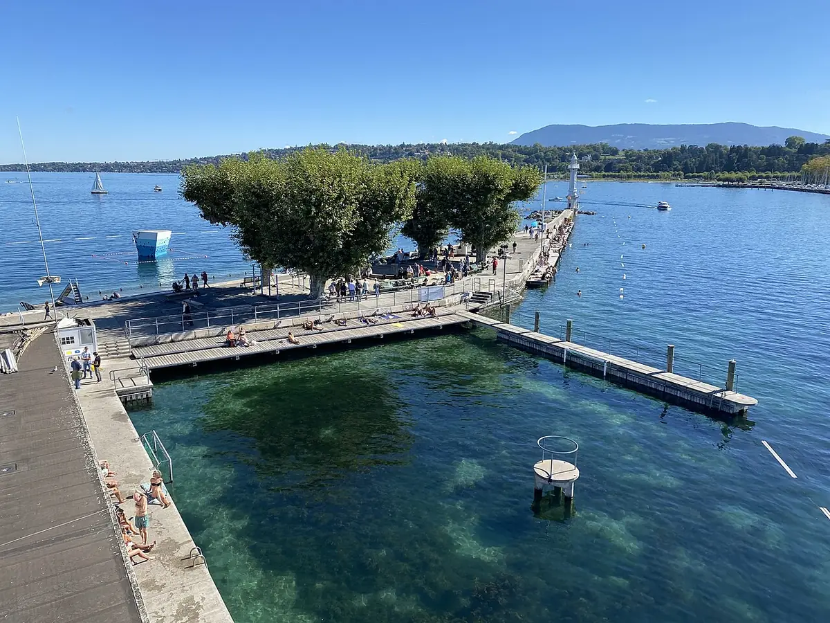 La jetée des bains des Pâquis sur le lac Léman, montagnes en arrière-plan