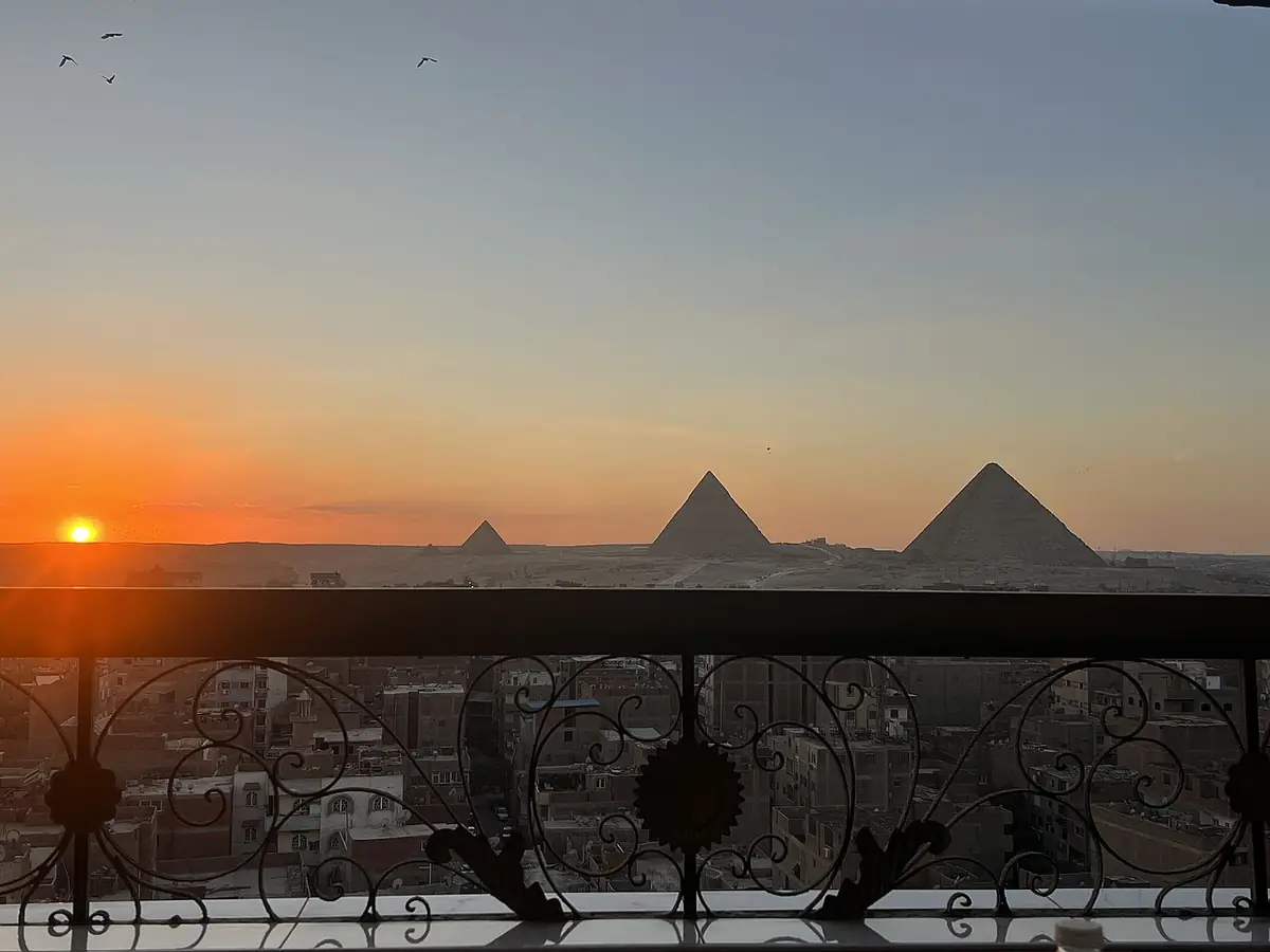 Les pyramides de Gizeh au coucher du soleil, vues depuis un balcon